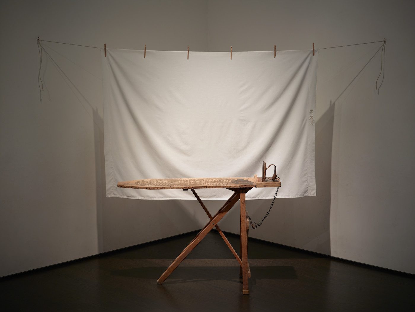Betye Saar, I’ll Bend But I Will Not Break, 1998. Mixed media tableau: vintage ironing board, flat iron, metal chin, white bed sheet, six wooden clothespins, cotton, clothesline and one rope hook, 80 x 96 x 36 in (203.2 x 243.8 x 91.4 cm), Los Angeles County Museum of Art, Gift of Lynda and Stewart Resnick through the 2018 Collectors Committee, © Betye Saar