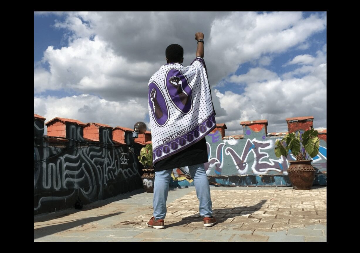 Kawira Mwirichia posing with her Kenya Kanga Flag, 2019. Quote by Ivy Gatibaru “Penzi Langu Halali,” meaning “My love is valid” in Swahili. Image from the artist’s Instagram.
