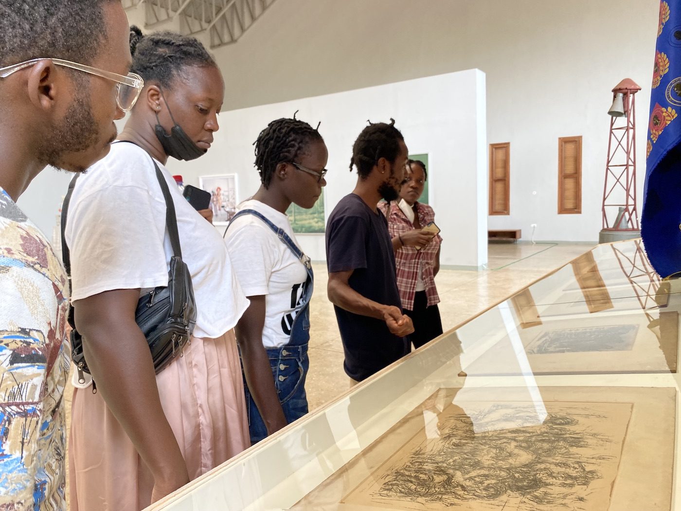 Selom Kudjie (in black), Artistic Director SCCA Tamale giving Ugandan artists a tour of A diagnosis of Time: Unlearn What You Have Learned.