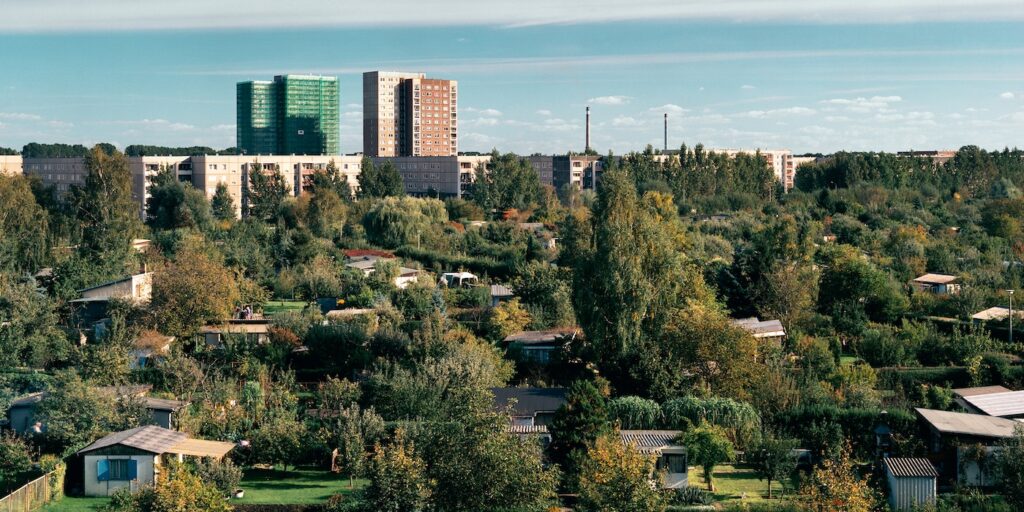 STAN DOUGLAS, VIEW OF “AN DER ALTEN ZAUCHE” WITH PLATTENBAUTEN, HOCHHÄUSERN AND THE TWIN SMOKESTACKS OF KOHLEHEIZWERK REHBRÜCKE, AM SCHLAATZ, 1994/95, FROM THE SERIES POTSDAMER SCHREBERGÄRTEN, 15 PARTS. HASSO PLATTNER COLLECTION, © STAN DOUGLAS, COURTESY THE ARTIST, VICTORIA MIRO AND DAVID ZWIRNER