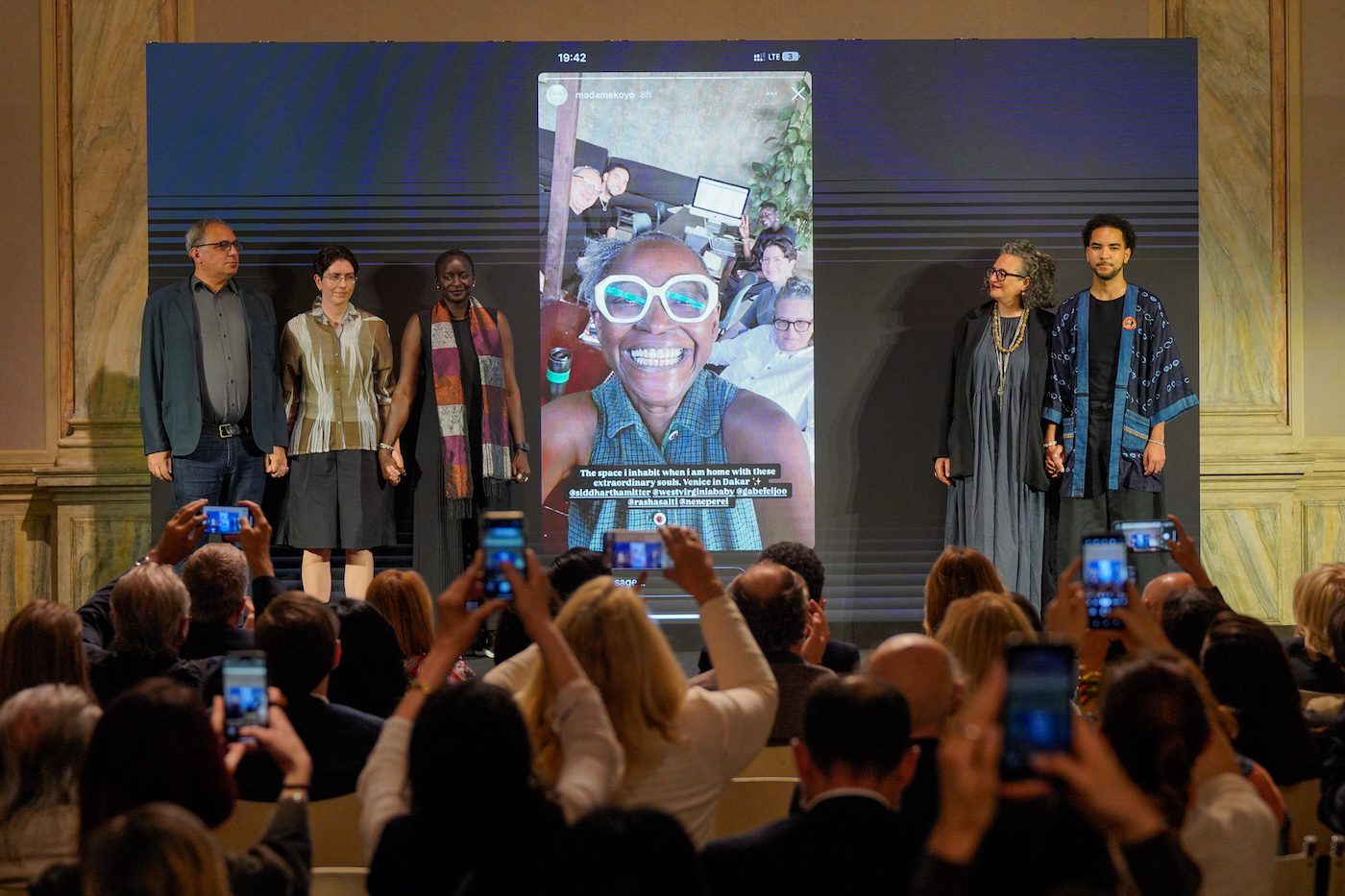The curatorial team (left to right) with Koyo Kouoh in the center: Siddhartha Mitter, Gabe Beckhurst Feijoo, Marie Hélène Pereira, Rasha Salti and Rory Tsapayi. Biennale Arte 2026. Photo by Andrea Avezzù. Courtesy of La Biennale di Venezia. 